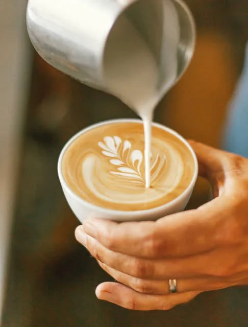 A GGET barista pouring latte art