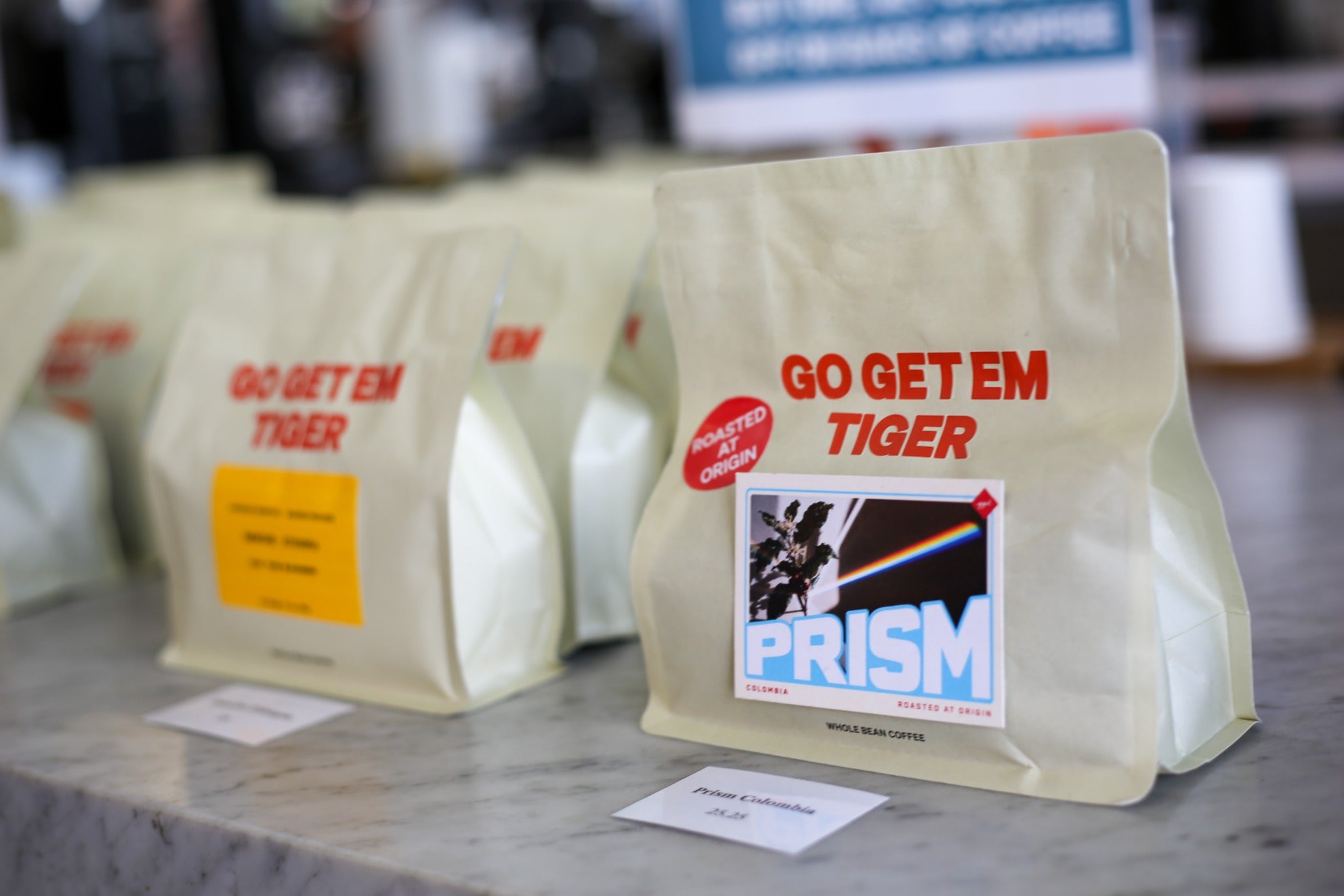 Prism coffee in its current bag with the red Roasted at Origin sticker
